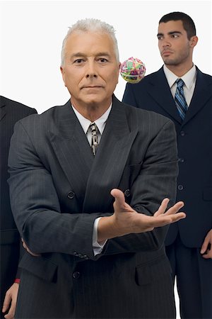 portrait of a group of clerks - Businessman catching a rubber band ball with two businessmen standing behind him Stock Photo - Premium Royalty-Free, Code: 625-02266650