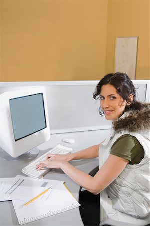 simsearch:625-02929867,k - Portrait of a young woman working on a computer and smiling Fotografie stock - Premium Royalty-Free, Codice: 625-02266669