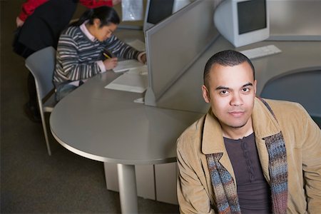 student computer writing - Portrait of a young man with another young man sitting behind him Stock Photo - Premium Royalty-Free, Code: 625-02266661
