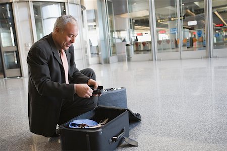 simsearch:625-02932677,k - Profil de côté d'un homme d'affaires d'emballage sa valise à l'aéroport Photographie de stock - Premium Libres de Droits, Code: 625-02266705