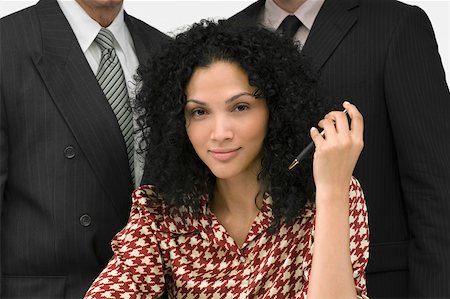 portrait of a group of clerks - Portrait of a businesswoman holding a pen with two businessmen behind her Stock Photo - Premium Royalty-Free, Code: 625-02266842