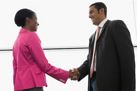 Side profile of a businessman and a businesswoman shaking hands at an airport Foto de stock - Sin royalties Premium, Código: 625-02266898