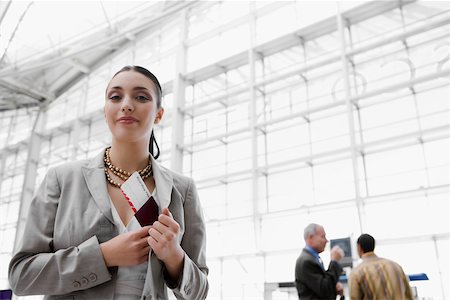 Businesswoman putting a passport with an airplane ticket in her coat's pocket Stock Photo - Premium Royalty-Free, Code: 625-02266906