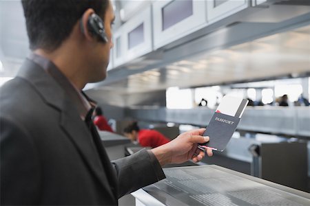 Side profile of a businessman holding a passport with an airplane ticket at an airport Foto de stock - Sin royalties Premium, Código: 625-02266914