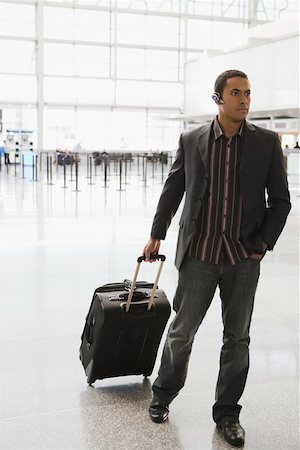 Homme d'affaires tirant ses bagages dans un aéroport Photographie de stock - Premium Libres de Droits, Code: 625-02266937