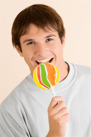 Portrait of a young man eating a lollipop Stock Photo - Premium Royalty-Free, Code: 625-02266959