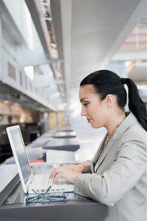 simsearch:625-02266955,k - Side profile of a businesswoman using a laptop at an airport Foto de stock - Royalty Free Premium, Número: 625-02266950