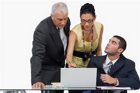 Two businessmen and a businesswoman discussing on a laptop in an office Stock Photo - Premium Royalty-Free, Code: 625-02266969