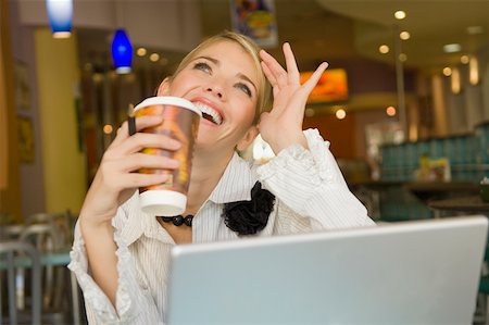 Businesswoman holding a disposable cup and smiling in a restaurant Stock Photo - Premium Royalty-Free, Code: 625-02267157