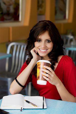 Portrait of a young woman holding a cup of cold drink and smiling Stock Photo - Premium Royalty-Free, Code: 625-02267165