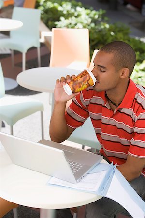 Young man sitting at a cafe and drinking coffee Stock Photo - Premium Royalty-Free, Code: 625-02267176