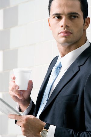 shirt folded - Side profile of a businessman holding a newspaper and a disposable cup Stock Photo - Premium Royalty-Free, Code: 625-02267184