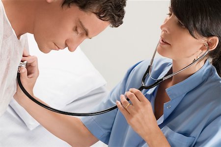 simsearch:625-02931429,k - Female doctor examining a mid adult man Stock Photo - Premium Royalty-Free, Code: 625-02267243