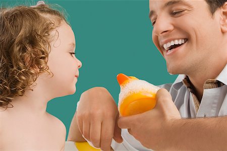 plastic toy family - Close-up of a mid adult man looking at his daughter and smiling Stock Photo - Premium Royalty-Free, Code: 625-02267324