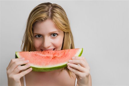 Portrait of a teenage girl eating a slice of watermelon Stock Photo - Premium Royalty-Free, Code: 625-02267532