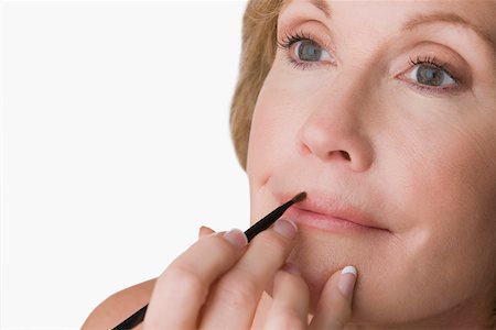 Close-up of a mature woman applying lip liner Stock Photo - Premium Royalty-Free, Code: 625-02267592