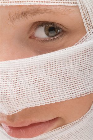 Close-up of a young woman's face wrapped with a bandage Stock Photo - Premium Royalty-Free, Code: 625-02267603