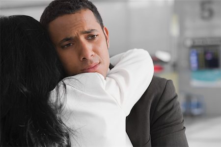 people hugging at airport - Close-up of a businessman and a businesswoman embracing each other at an airport Stock Photo - Premium Royalty-Free, Code: 625-02267692