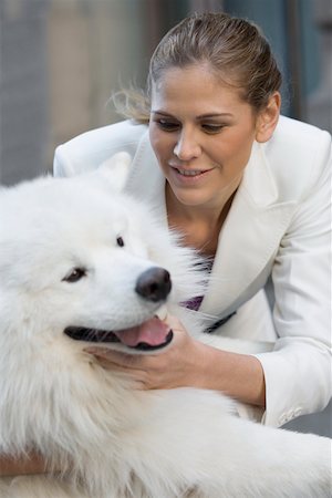 Close-up of a businesswoman playing with her dog Stock Photo - Premium Royalty-Free, Code: 625-02267718