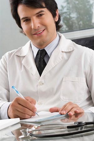 simsearch:625-02933219,k - Male doctor writing on a notepad with a pen Foto de stock - Sin royalties Premium, Código: 625-02267786