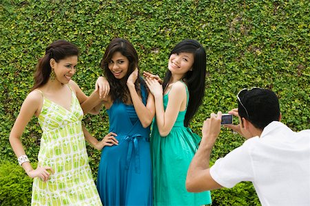 simsearch:625-02267530,k - Rear view of a mid adult man photographing three young women with a digital camera Stock Photo - Premium Royalty-Free, Code: 625-02267799