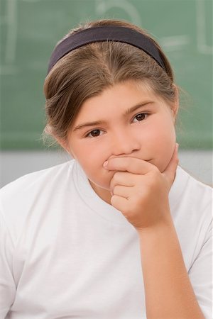 Portrait of a schoolgirl thinking in a classroom Stock Photo - Premium Royalty-Free, Code: 625-02267811