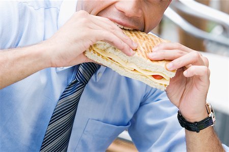 simsearch:625-02933216,k - Close-up of a businessman eating a cheese sandwich Foto de stock - Sin royalties Premium, Código: 625-02267833