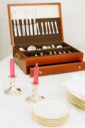 simsearch:630-02220328,k - Two burning candles with a cutlery box and stacks of plates on a dining table Fotografie stock - Premium Royalty-Free, Codice: 625-02926450