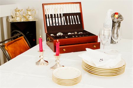 simsearch:625-02926486,k - Two burning candles with a cutlery box and stacks of plates on a dining table Stock Photo - Premium Royalty-Free, Code: 625-02926469