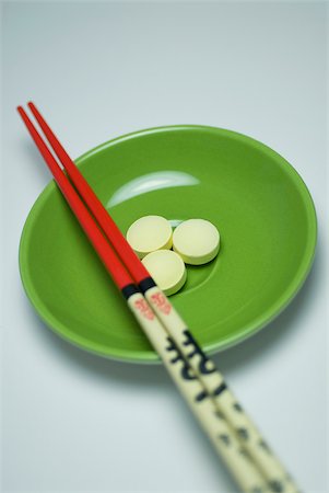 simsearch:625-02267134,k - Close-up of three pills in a bowl with two chopsticks Fotografie stock - Premium Royalty-Free, Codice: 625-02927285