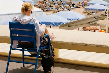 Vue arrière d'une femme assise dans un fauteuil sur la plage, Plage De La Croisette, Cannes, Provence-Alpes-Cote d'Azur, PACA, France Photographie de stock - Premium Libres de Droits, Code: 625-02928189