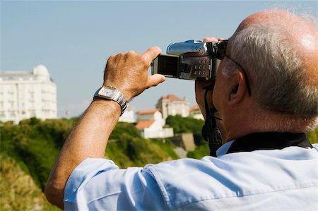 simsearch:625-02928803,k - Rear view of a man filming with his home video camera, Biarritz, Basque Country, Pyrenees-Atlantiques, Aquitaine, France Fotografie stock - Premium Royalty-Free, Codice: 625-02928318