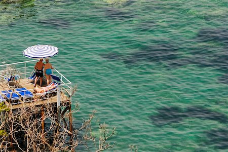 High angle view of a couple standing on a boardwalk, Bay of Naples, Sorrento, Sorrentine Peninsula, Naples Province, Campania, Italy Stock Photo - Premium Royalty-Free, Code: 625-02928451