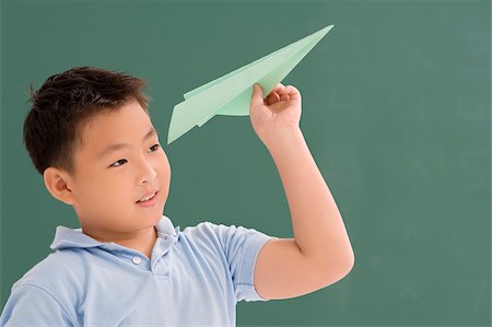 Close-up of a schoolboy playing with a paper airplane Stock Photo - Premium Royalty-Free, Code: 625-02928946