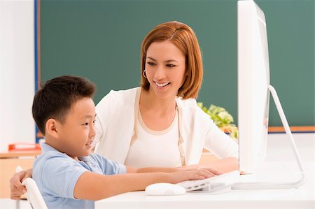 simsearch:625-02930309,k - Profil de côté d'un écolier avec son professeur devant un ordinateur Photographie de stock - Premium Libres de Droits, Code: 625-02928952