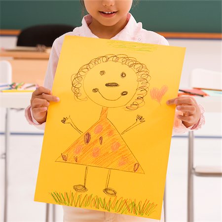 Close-up of a schoolgirl showing her drawing and smiling Stock Photo - Premium Royalty-Free, Code: 625-02928986