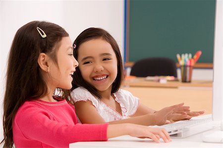 simsearch:625-02930966,k - Two schoolgirls smiling in front of a computer Stock Photo - Premium Royalty-Free, Code: 625-02928998