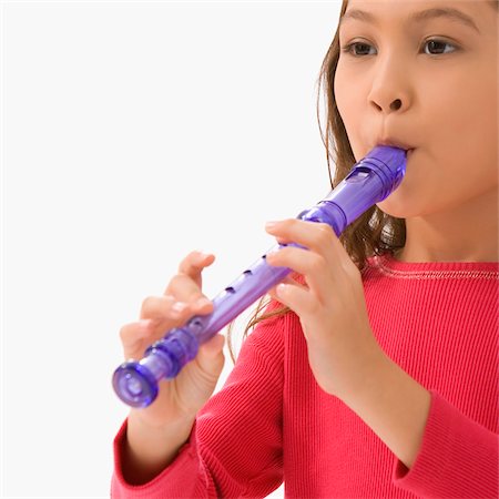 Close-up of a schoolgirl playing a flute in a classroom Foto de stock - Sin royalties Premium, Código: 625-02929000