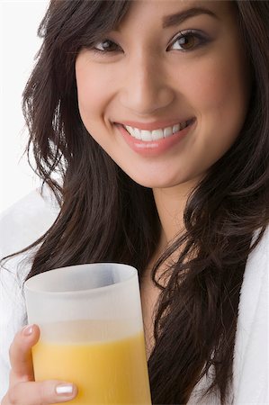 simsearch:625-02929093,k - Portrait of a young woman holding a glass of orange juice and smiling Stock Photo - Premium Royalty-Free, Code: 625-02929029