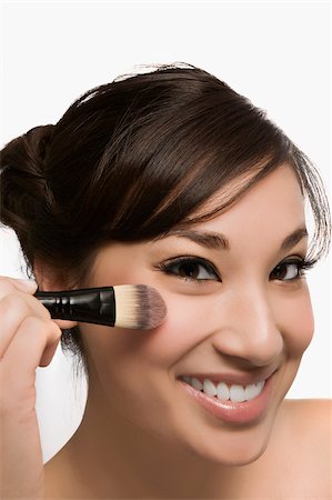 simsearch:625-02267557,k - Portrait of a young woman holding a make-up brush and smiling Stock Photo - Premium Royalty-Free, Code: 625-02929023