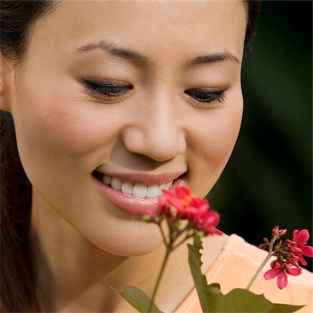 simsearch:625-02929099,k - Nahaufnahme einer jungen Frau eine Blume zu betrachten und das Lächeln Stockbilder - Premium RF Lizenzfrei, Bildnummer: 625-02929073