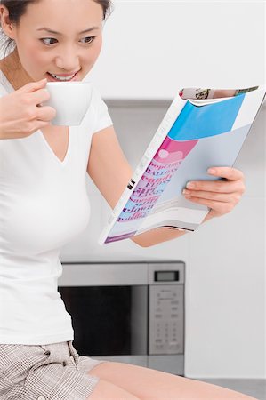 simsearch:625-02929093,k - Side profile of a young woman drinking tea and reading a magazine Stock Photo - Premium Royalty-Free, Code: 625-02929100