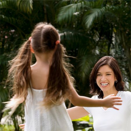 Rear view of a girl running to hug her mother in a park Stock Photo - Premium Royalty-Free, Code: 625-02929167