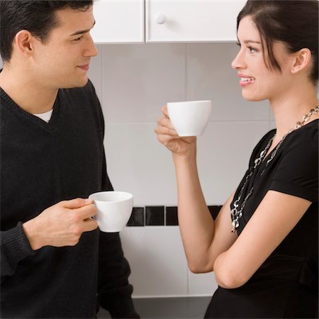 simsearch:625-02929093,k - Young couple holding cups of tea and looking at each other Stock Photo - Premium Royalty-Free, Code: 625-02929168