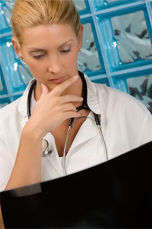 Female doctor examining an X-Ray report Stock Photo - Premium Royalty-Free, Code: 625-02929210