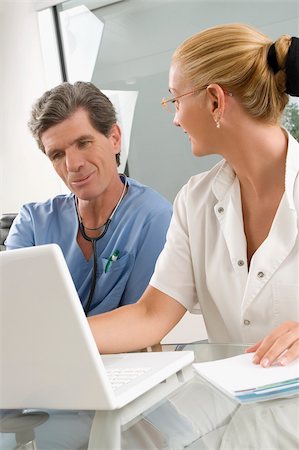 Female doctor discussing with a male surgeon at a clinic Foto de stock - Sin royalties Premium, Código: 625-02929245