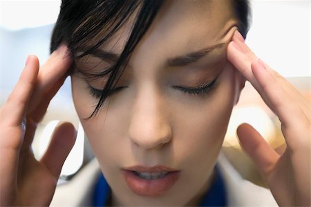 Close-up of a businesswoman suffering from a headache Stock Photo - Premium Royalty-Free, Code: 625-02929448