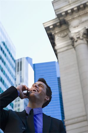 Low angle view of a businessman talking on a mobile phone and laughing Stock Photo - Premium Royalty-Free, Code: 625-02929506