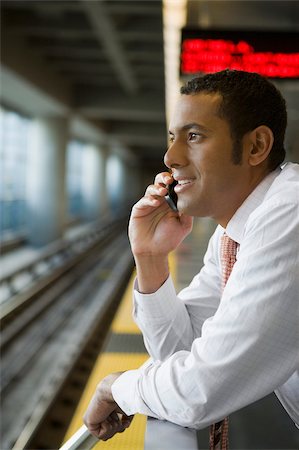 Profil de côté d'un homme d'affaires parlant sur un téléphone portable à une station de métro Photographie de stock - Premium Libres de Droits, Code: 625-02929510