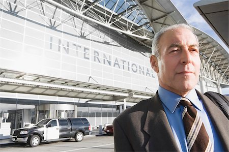 Close-up of a businessman in front of an airport Stock Photo - Premium Royalty-Free, Code: 625-02929589
